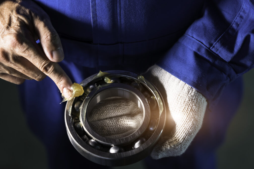 Mechanic is putting yellow grease in the into bearing, engineering and industrial concept"n